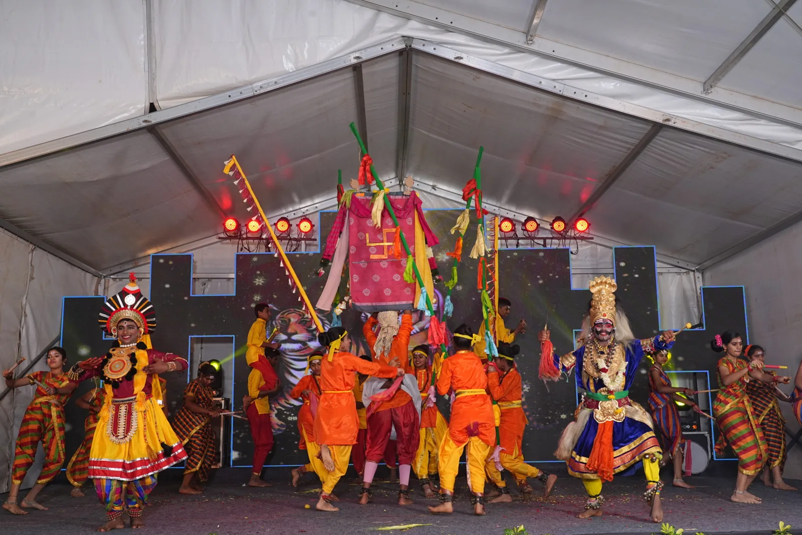 Students dressed as mythological characters performing on a decorated stage
