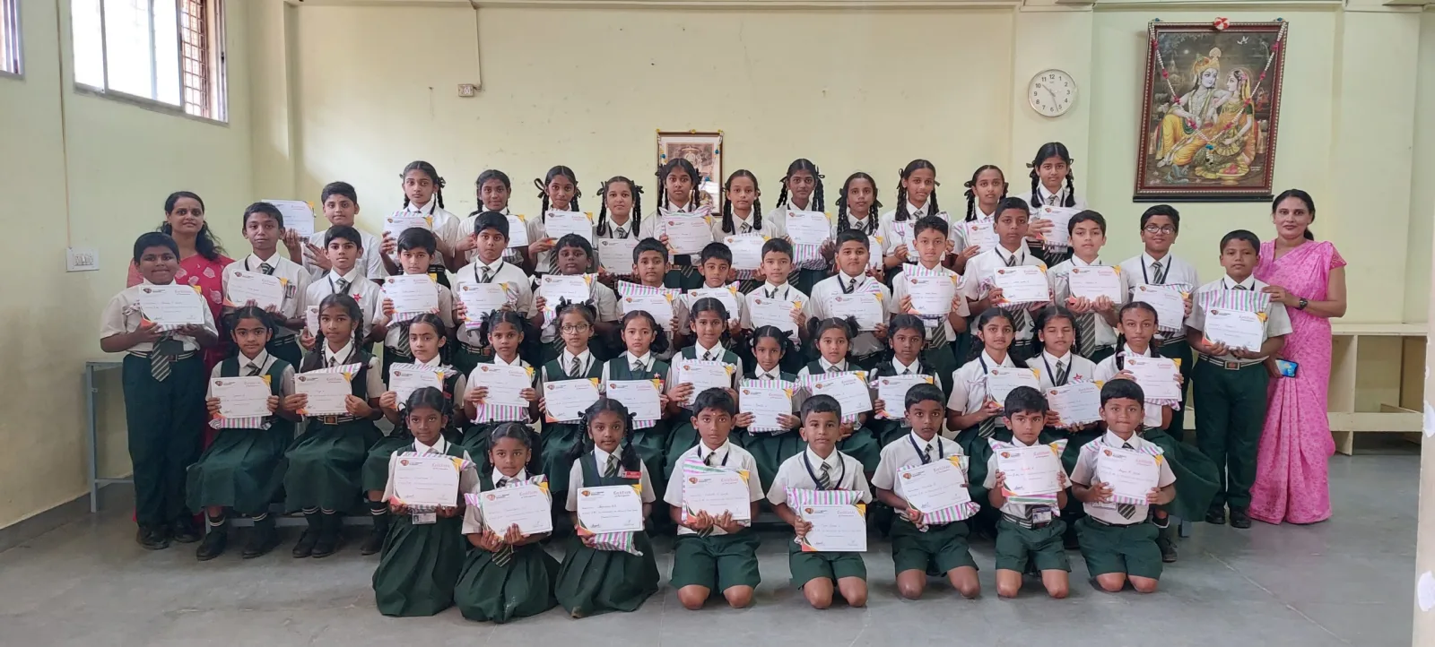 A large group of students holding certificates together in a classroom