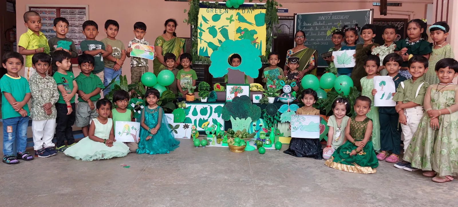 Students dressed in green for a themed celebration day, surrounded by green decorations