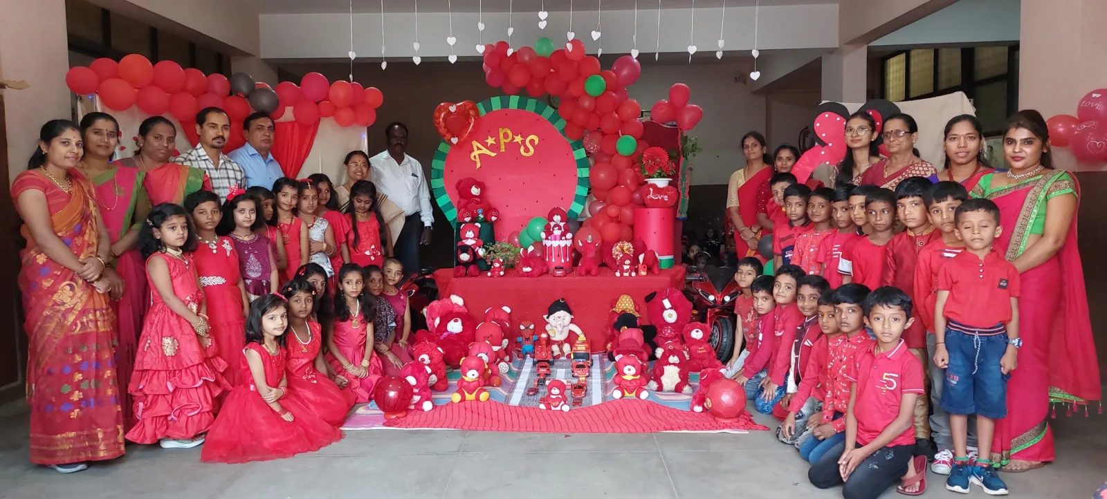 Students and staff dressed in red for a themed celebration day, surrounded by red decorations