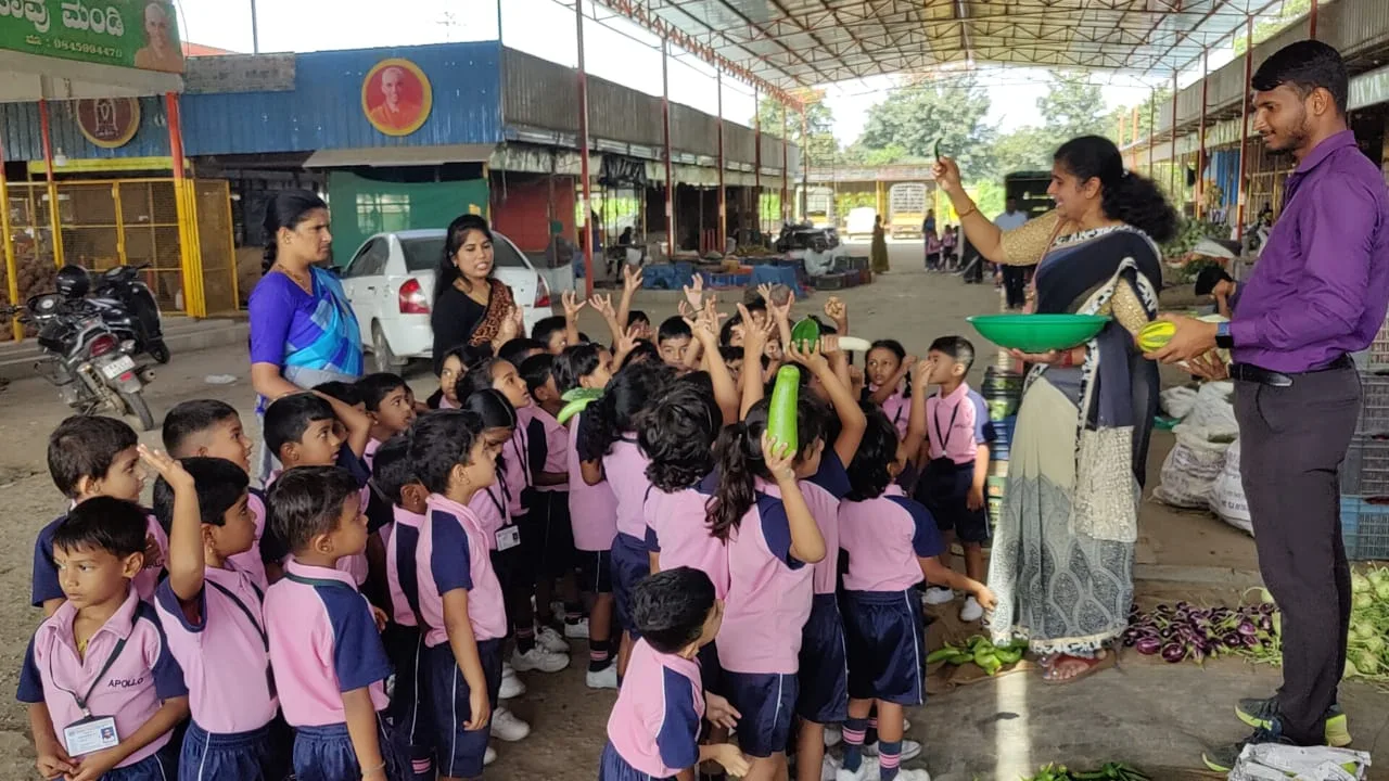 Students and staff gathered around crates of vegetables for a community donation drive