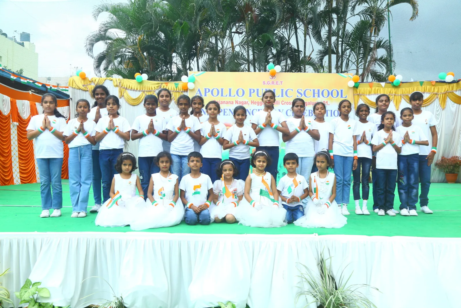 Students dressed in army-style costumes saluting on stage for Independence Day