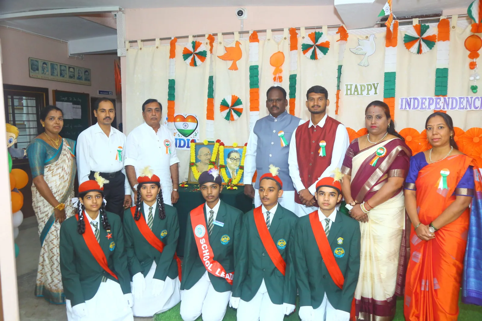School management and staff posing together on stage for Independence Day celebrations