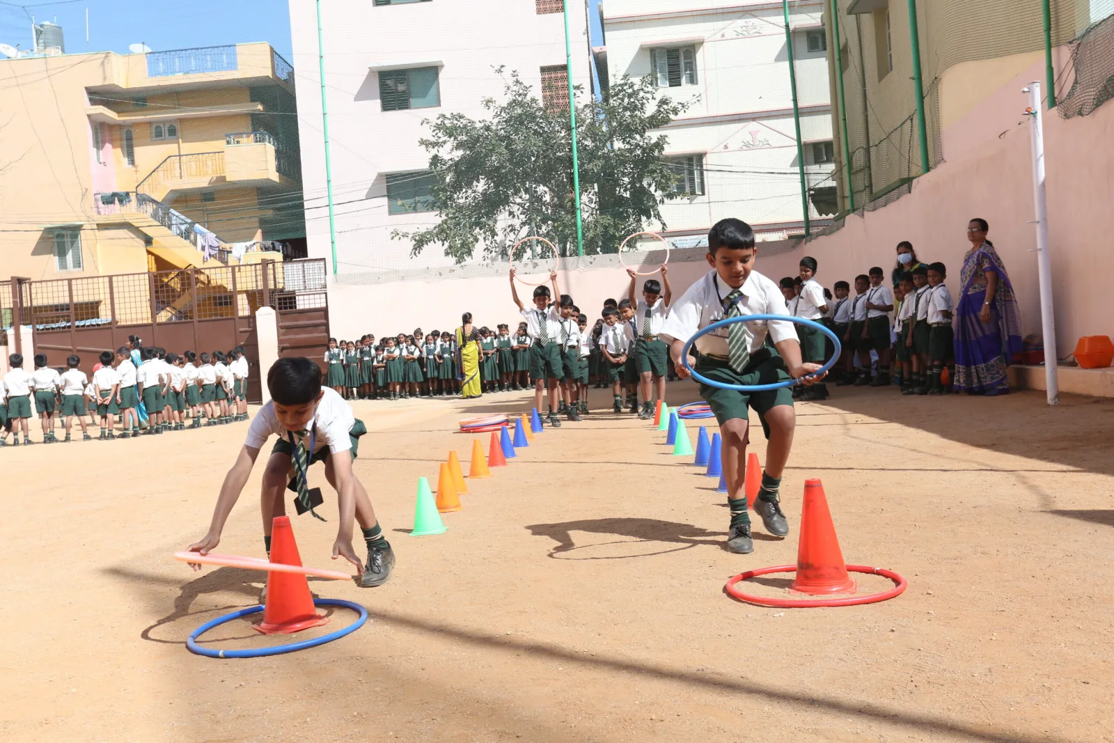 A student running a cone-and-hurdle race on the school ground